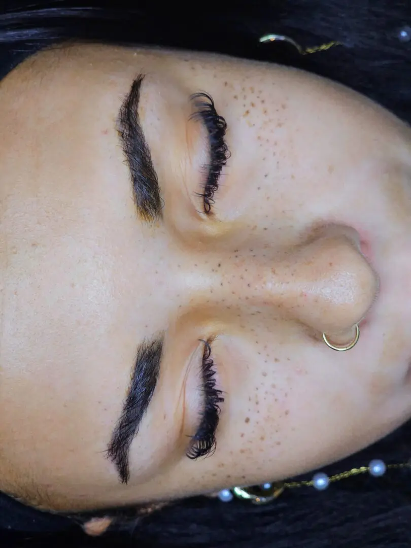 Close-up closed eyes, freckles, eyelashes, nose ring